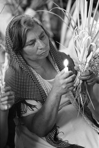 An old woman burns a candle, San Salvador, 1982