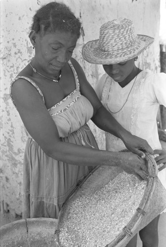 Woman pouring corn into mortar, San Basilio del Palenque, ca. 1978