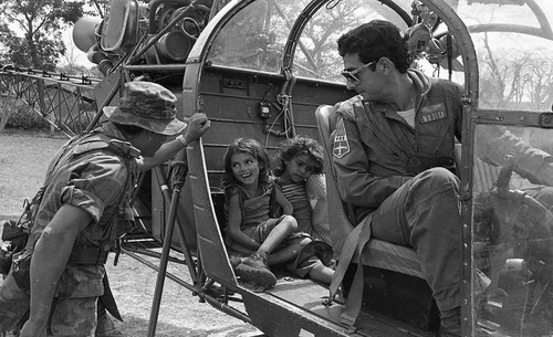 Two girls sit inside a helicopter, Caban?as, 1982