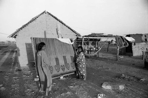 Wayuu women carry large weaving, La Guajira, Colombia, 1976