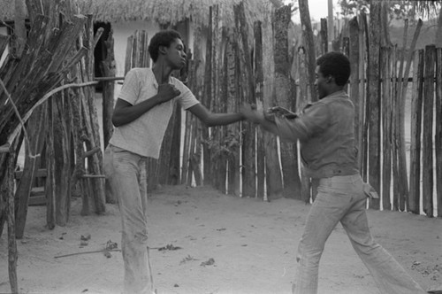 Boys boxing in front of a fence, San Basilio del Palenque, ca. 1978