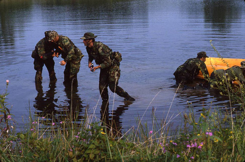 Survival school students stand near a raft, Liberal, 1982