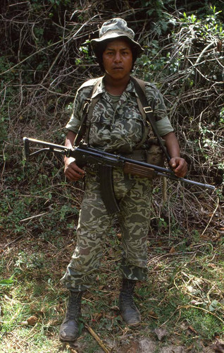 An armed soldier stands for a photo while on patrol, Guatemala, 1982