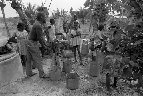 Man pumping water from a hand pump, San Basilio de Palenque, 1977