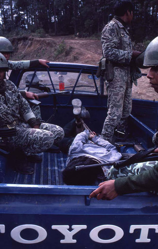 Soldiers and a hogtied man, Guatemala, 1982