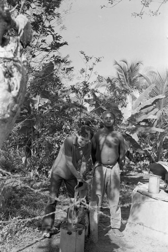 Richard Cross and a man standing in front of a hand pump, San Basilio de Palenque, ca. 1978