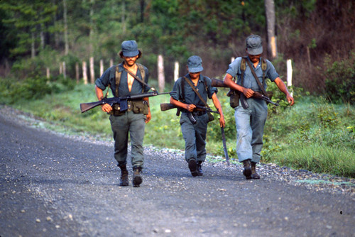 Three Contras walk along a road, Nicaragua, 1983