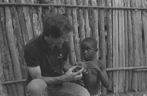 Richard Cross and a boy examining a toy camera, San Basilio de Palenque, 1977