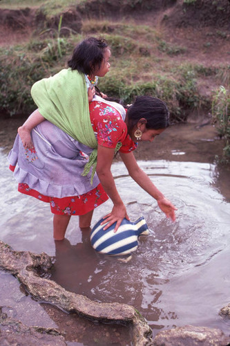 Guatemalan refugee collects water at a river, Cuauhtémoc, 1983