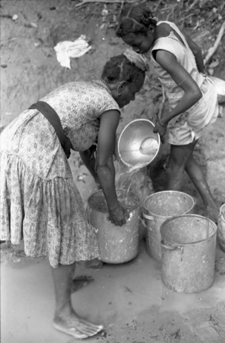 Woman collects water at river, San Basilio de Palenque, 1975