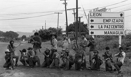 Sandinistas pose in front of a road sign, Nicaragua, 1979