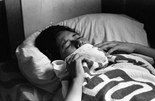 Injured woman in bed, Nicaragua, 1979