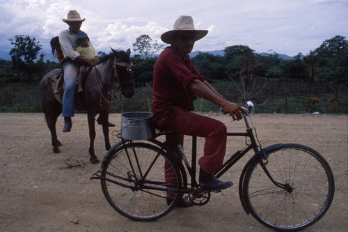 Man on horse and man on bicycle, Honduras, 1983