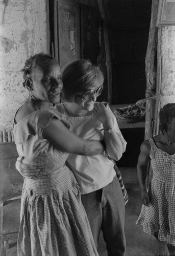 Nina S. de Friedemann hugging a women,, San Basilio del Palenque, ca. 1978