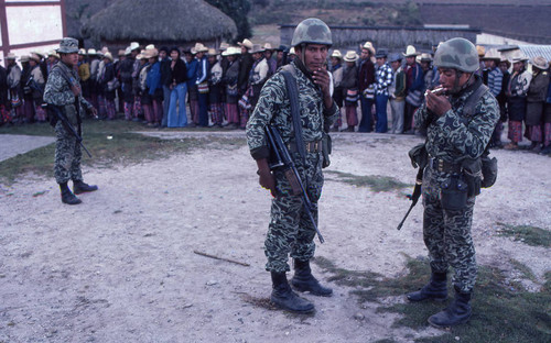 Three soldiers and a group of Mayan men in line to vote, Nahualá, 1982