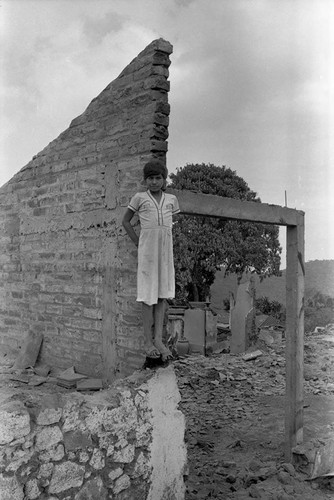 Girl standing on the edge of a destroyed wall, Berlín, 1983