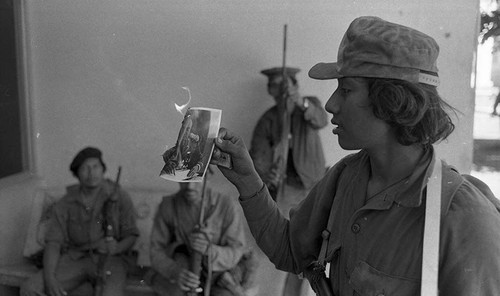 Sandinista burns a photo of Dictator Anastasio Somoza Garcia, Nicaragua, 1979