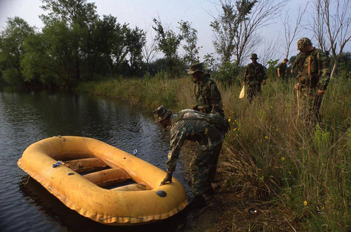 Survival school students stand near a raft, Liberal, 1982