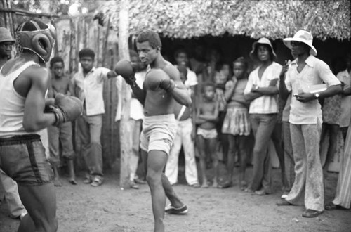 Two men boxing outdoor in front of crowd, San Basilio de Palenque, 1975