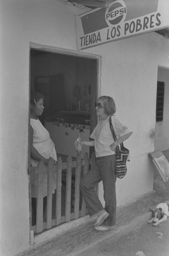 Nina S. de Friedemann and woman talking at doorway, San Basilio de Palenque, ca. 1978