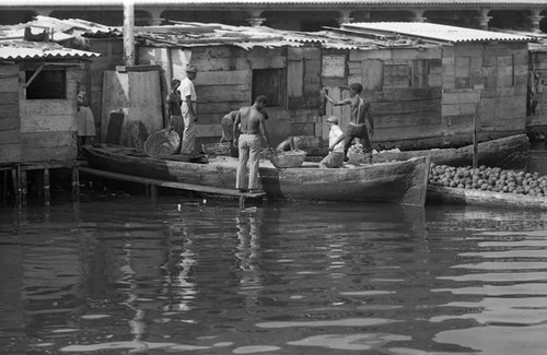 Men unload fruits from boats, Cartagena Province, 1975