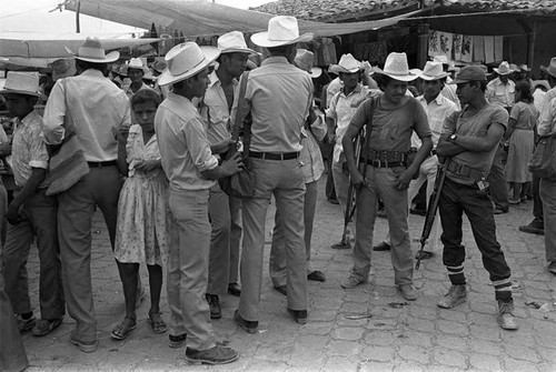 Girl walking amongst guerrilleros, Corinto, Morazán, 1983