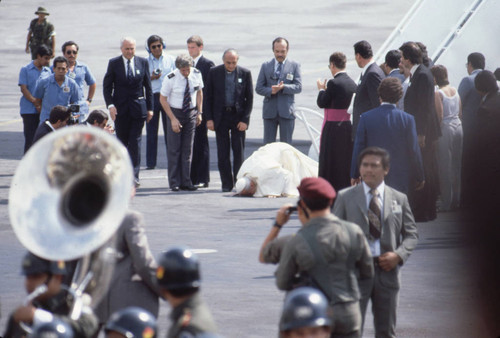 Pope John Paul II kneeling on his arrival, San Salvador, El Salvador, 1983