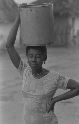 A young woman carries water bucket, San Basilio de Palenque, 1977