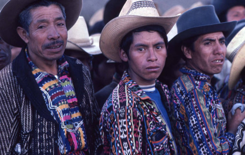 Three Mayan men wait in line to vote, Guatemala, 1982