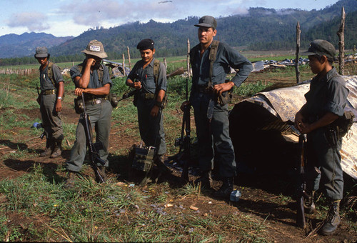 A child soldier stands with two older Contra soldiers, Nicaragua, 1983