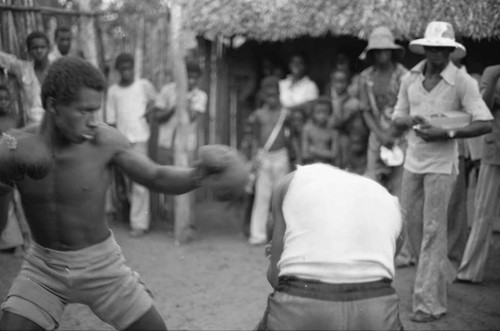 Two men boxing outdoor in front of crowd, San Basilio de Palenque, 1975