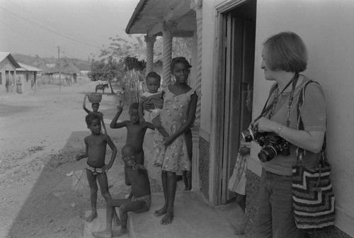 Nina S. de Friedemann and children standing in front of a house, San Basilio de Palenque, ca. 1978