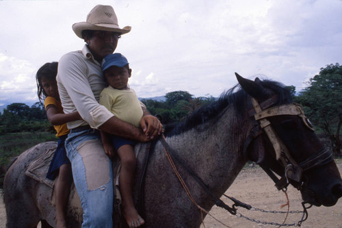 Man on a horse with children, Honduras, 1983