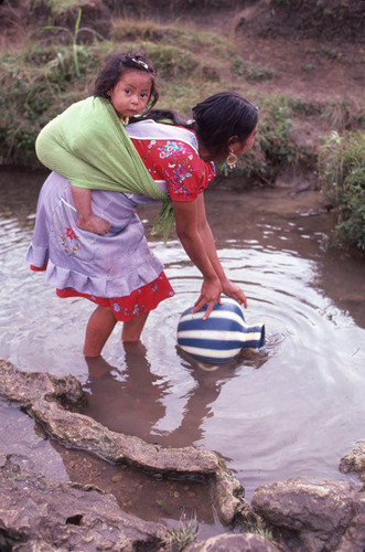 Guatemalan refugee collects water at a river, Cuauhtémoc, 1983