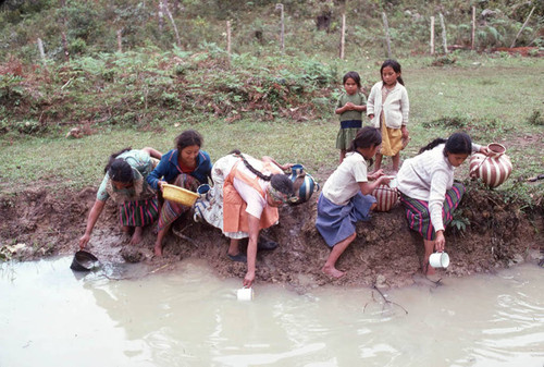 Guatemalan refugees collecting water at a River, Santiago el Vértice, 1983