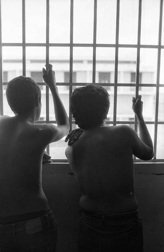 Prisoners look through bars, Nicaragua, 1980