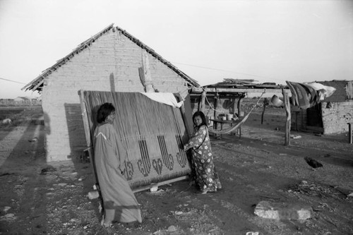 Wayuu women carry large weaving, Guajira, La Guajira, Colombia, 1976