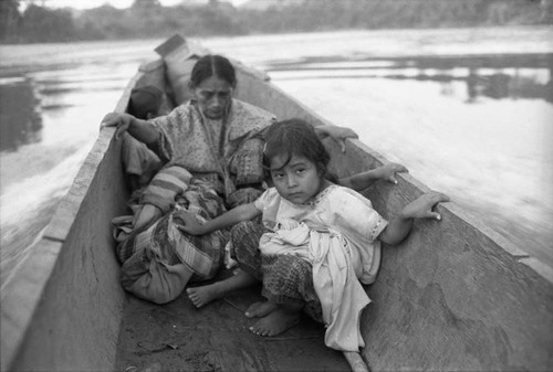 Refugee woman and three children in a canoe, Chiapas, 1983