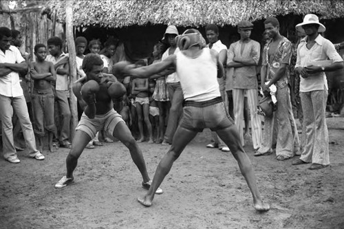 Two men boxing outdoor in front of crowd, San Basilio de Palenque, 1975