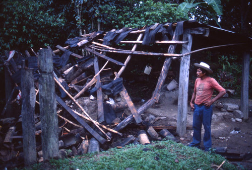 Man looks at destroyed shack, Honduras, 1983