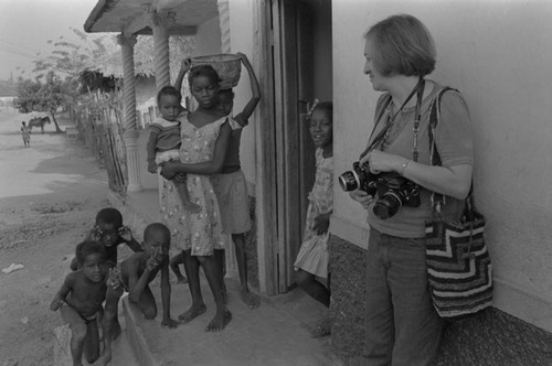 Anthropologist and group of children standing in front of a house, San Basilio de Palenque, ca. 1978