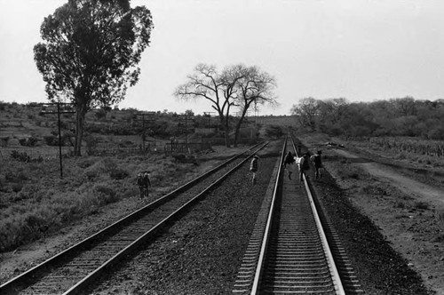 People walk over train tracks, Mexico, 1983