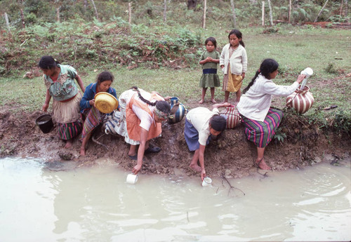 Guatemalan refugees collect water at a river, Santiago el Vértice, 1983