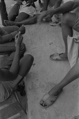 Men playing a game on sidewalk, San Basilio de Palenque, ca. 1978