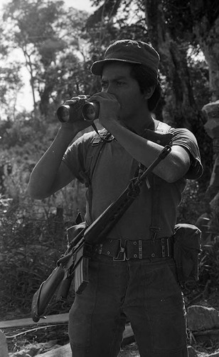 Soldier looking through binoculars, Morazán, 1983