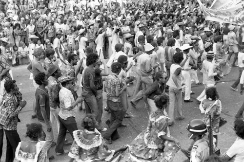 Carnival crowd walking along the street, Barranquilla, Colombia, 1977