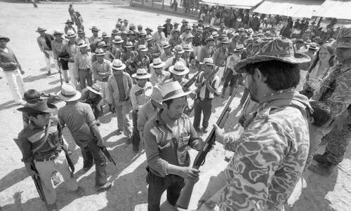 Unidentified soldier hands off a shotgun, Chajul, 1982