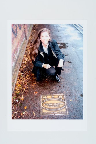 Carolyn Jensen (Babe's granddaughter) kneeling next to Slater's plaque on the Rugby Pathway of Fame, Rugby, Warwickshire, United Kingdom