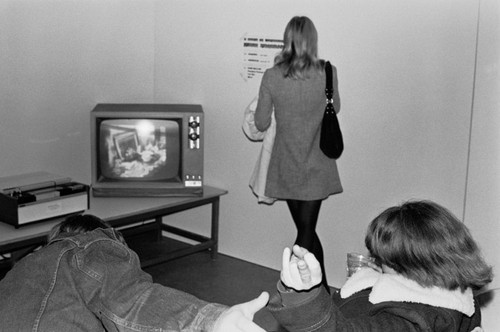 Students watching video at art exhibition