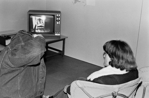 Students watching video at art exhibition